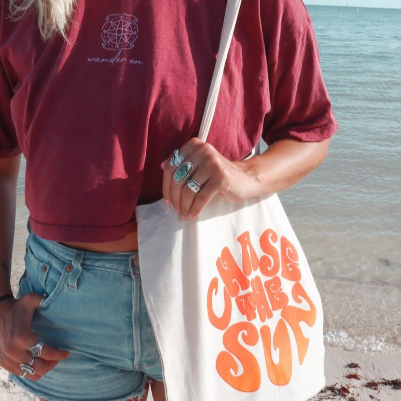 "Chase The Sun" canvas tote bag paired with "Wander On" crop